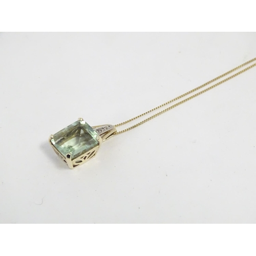 625 - A 9ct gold pendant set with pale green spinel and diamonds on a 16