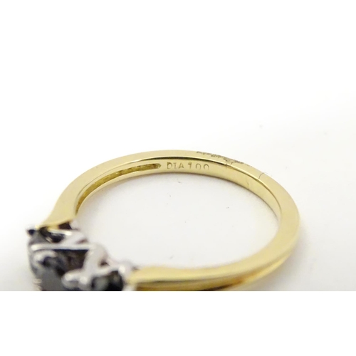 534 - An 18ct gold ring set with trio of black diamonds. Ring size approx O