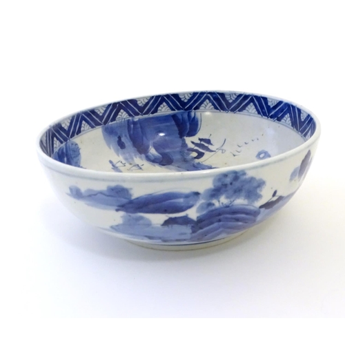 15 - A Chinese blue and white bowl with hand painted decoration depicting an Oriental landscape with pago... 