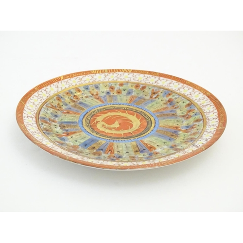 16 - An Oriental plate in the Kutani palette the centre with stylised dragon detail, with banded motif bo... 