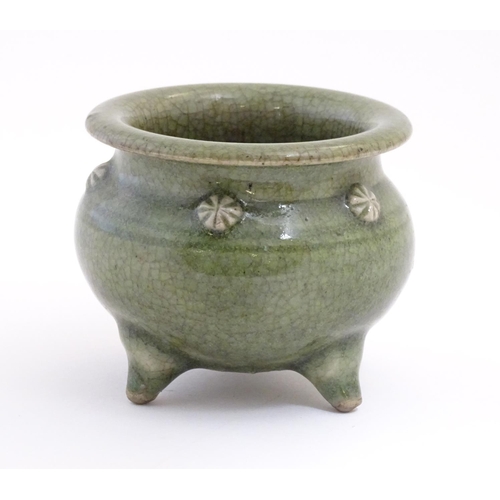 25 - A Chinese three footed censor with a crackle glaze and floral roundels in relief. Approx. 3 1/4