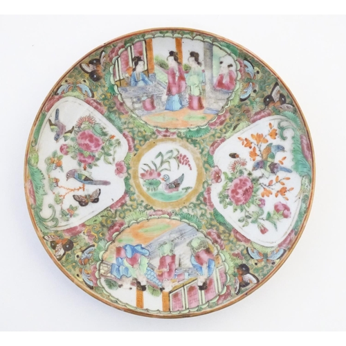36 - A Chinese Cantonese famille rose plate with panelled decoration depicting figures on a terrace, and ... 