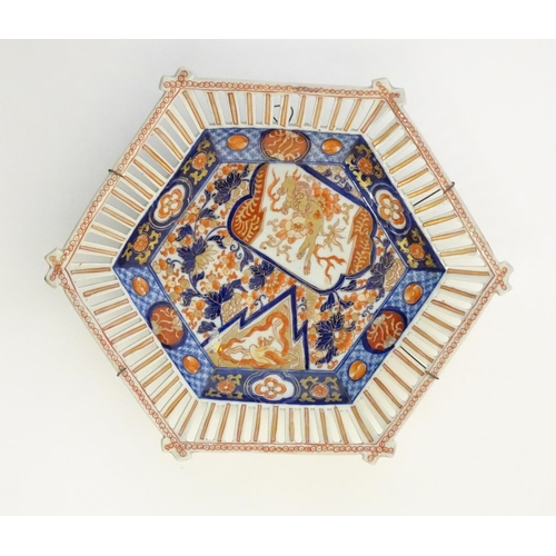37 - A Japanese dish of hexagonal form with a reticulated border, the centre decorated with a stylised dr... 