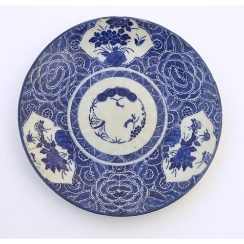 44 - An Oriental blue and white plate with stylised peony detail, and stylised scrolling flower motifs to... 