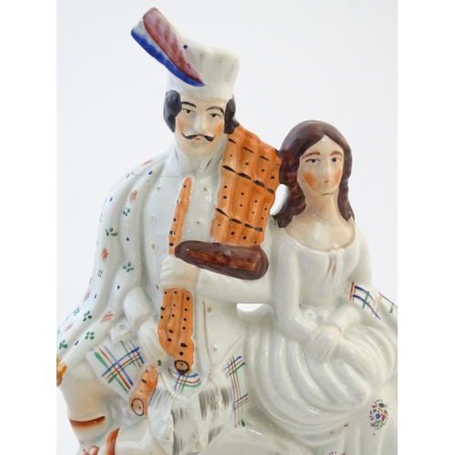 63 - A Staffordshire flat back figural group depicting a Scottish highland couple with clock detail below... 