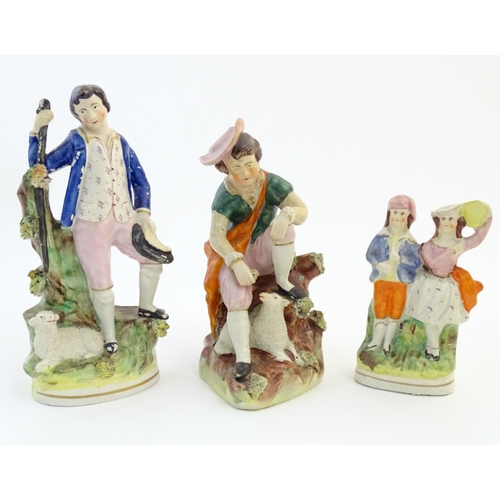 67 - Five assorted Staffordshire pottery figures comprising two models of shepherds and their sheep, two ... 