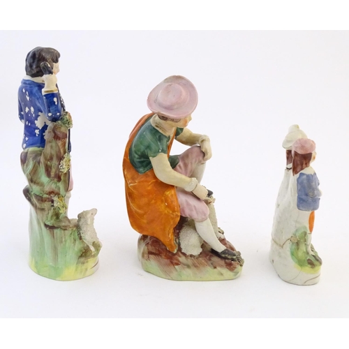 67 - Five assorted Staffordshire pottery figures comprising two models of shepherds and their sheep, two ... 