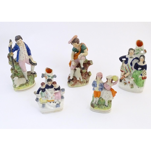 67 - Five assorted Staffordshire pottery figures comprising two models of shepherds and their sheep, two ... 