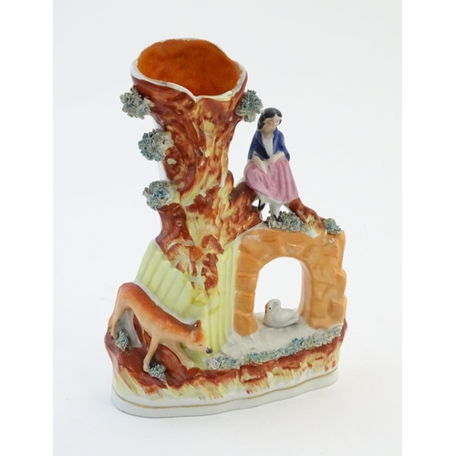 70 - A Staffordshire pottery flat back bud vase depicting a girl on a bridge next to a tree with a fox st... 