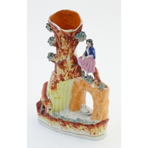 70 - A Staffordshire pottery flat back bud vase depicting a girl on a bridge next to a tree with a fox st... 