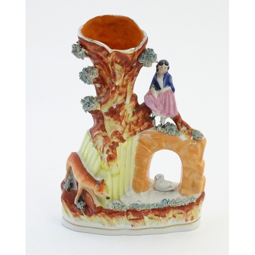 70 - A Staffordshire pottery flat back bud vase depicting a girl on a bridge next to a tree with a fox st... 