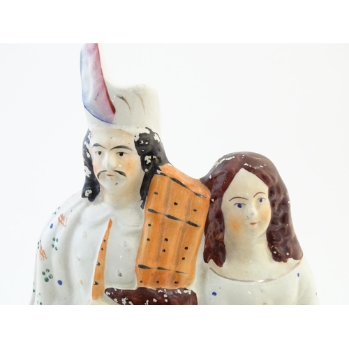 71 - A Staffordshire flat back figural group depicting a Scottish highland couple with clock detail below... 