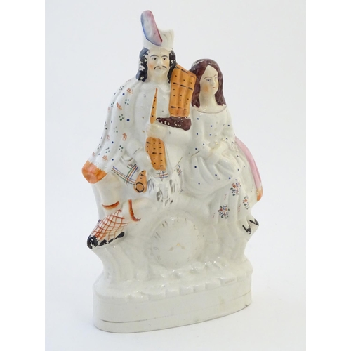 71 - A Staffordshire flat back figural group depicting a Scottish highland couple with clock detail below... 