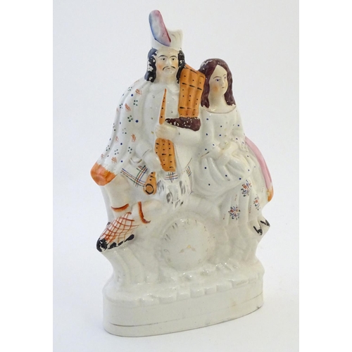 71 - A Staffordshire flat back figural group depicting a Scottish highland couple with clock detail below... 