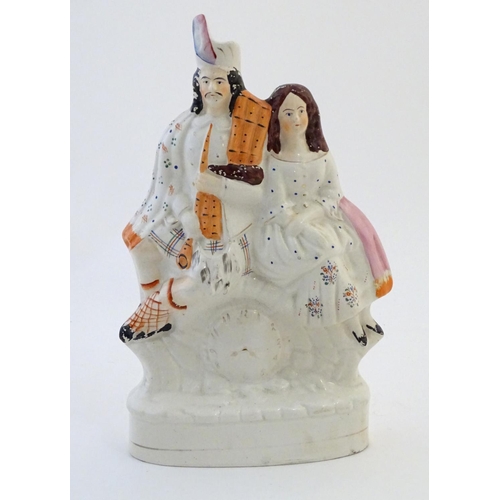 71 - A Staffordshire flat back figural group depicting a Scottish highland couple with clock detail below... 