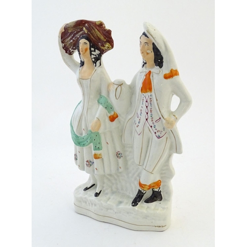 72 - A Staffordshire pottery flat back figural group depicting a harvest couple, the man carries a flagon... 