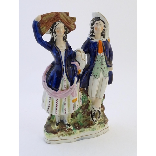 75 - A Staffordshire pottery flat back figural group depicting a harvest couple, the man carries a flagon... 