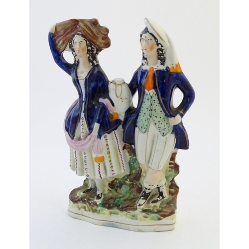 75 - A Staffordshire pottery flat back figural group depicting a harvest couple, the man carries a flagon... 