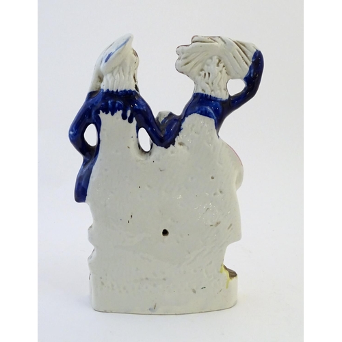 75 - A Staffordshire pottery flat back figural group depicting a harvest couple, the man carries a flagon... 