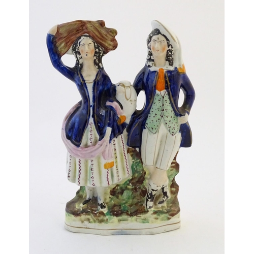 75 - A Staffordshire pottery flat back figural group depicting a harvest couple, the man carries a flagon... 