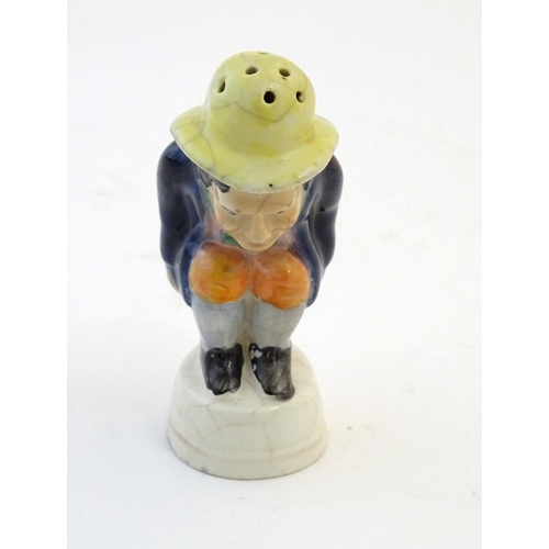 78 - An early 19thC Staffordshire comical / novelty pepper pot modelled as Roger Giles squatting. Approx.... 