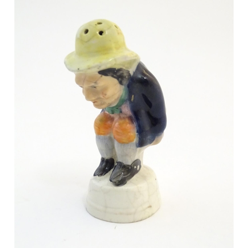 78 - An early 19thC Staffordshire comical / novelty pepper pot modelled as Roger Giles squatting. Approx.... 