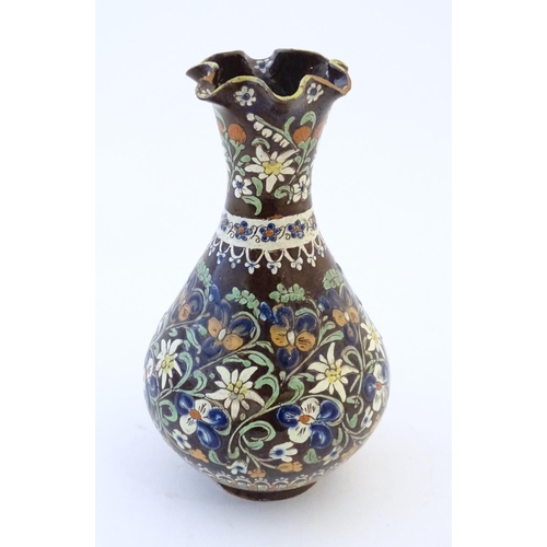 102 - A 19thC Swiss Thoune style vase with a fluted rim and flower decoration. Approx. 10 1/4