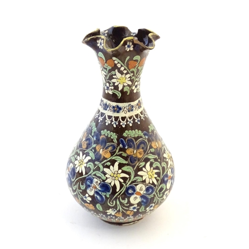 102 - A 19thC Swiss Thoune style vase with a fluted rim and flower decoration. Approx. 10 1/4