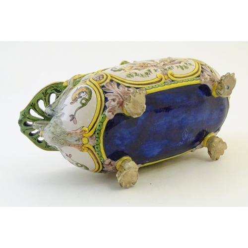 116 - An Italian faience planter of oblong form on claw feet with panelled grotesque decoration depicting ... 