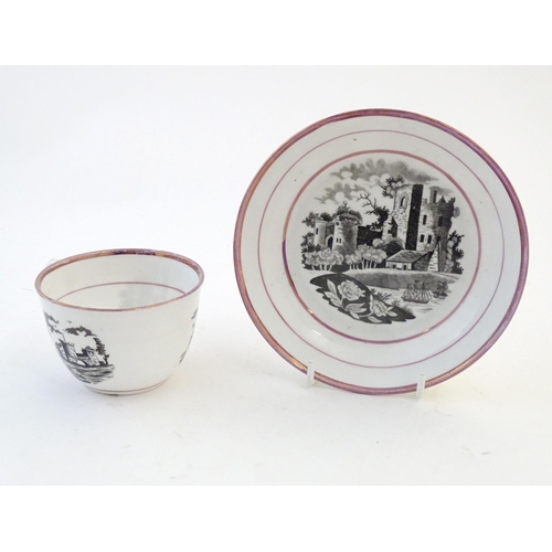 118 - A tea cup and saucer with monochrome transfer decoration depicting a river landscape with a ship and... 