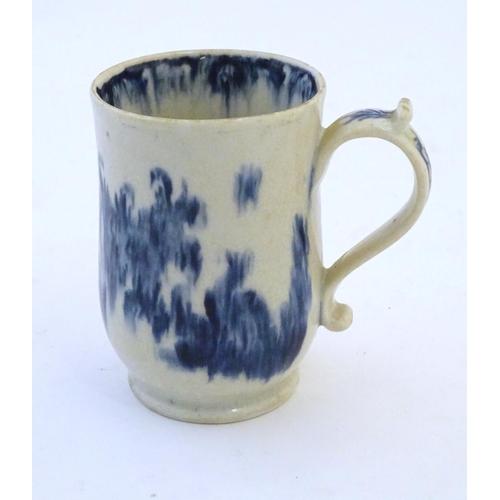 123 - A late 19th / early 20thC French copy of an Abraham Moore Lowestoft blue and white mug with floral d... 