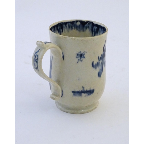 123 - A late 19th / early 20thC French copy of an Abraham Moore Lowestoft blue and white mug with floral d... 