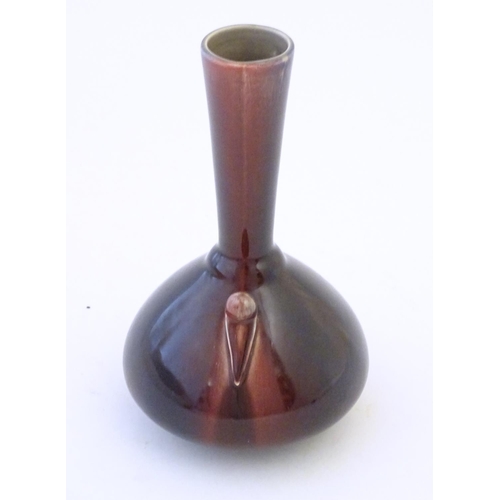 141 - An Arts & Crafts Linthorpe style flambe bottle vase with a flared rim and styled twin handles. Impre... 