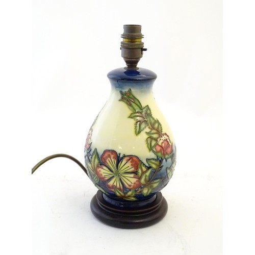 142 - A Moorcroft style lamp base with tube lined decoration depicting flowers and foliate. Approx. 10 3/4... 