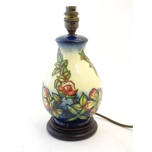 142 - A Moorcroft style lamp base with tube lined decoration depicting flowers and foliate. Approx. 10 3/4... 