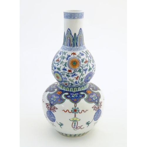 1 - A Chinese double gourd vase with doucai style decoration with scrolling floral and foliate detail. C... 