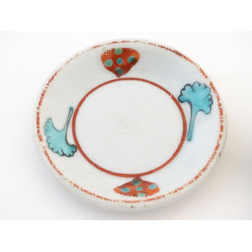 112 - A small saucer with naive hand painted decoration, together with a small tea bowl decorated with the... 