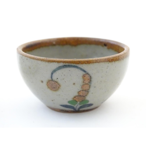 112 - A small saucer with naive hand painted decoration, together with a small tea bowl decorated with the... 