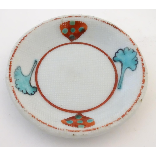 112 - A small saucer with naive hand painted decoration, together with a small tea bowl decorated with the... 