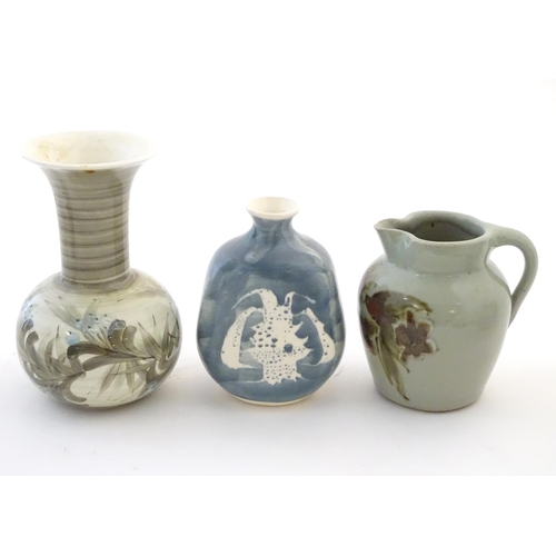 114 - Three studio pottery items comprising a small jug by Caroline Eeles with floral and foliate detail, ... 