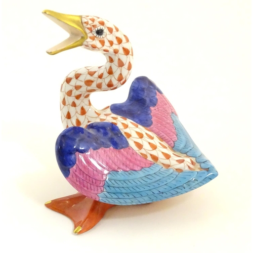 126 - A Herend pottery model of a honking goose with fishnet decoration and gilt highlights. Marked under.... 