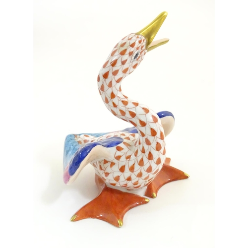 126 - A Herend pottery model of a honking goose with fishnet decoration and gilt highlights. Marked under.... 