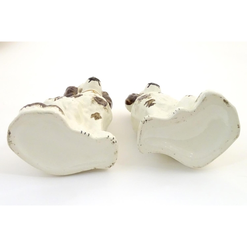 62A - A pair of Staffordshire pottery seated spaniels, together with another smaller example. Largest appr... 