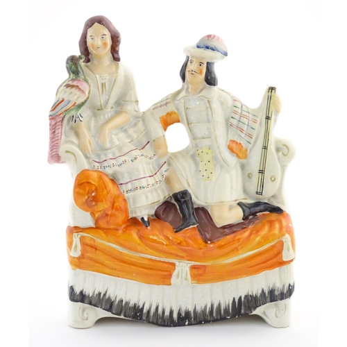 65 - A Staffordshire flatback figural group of a man with a musical instrument and a woman with a parrot,... 