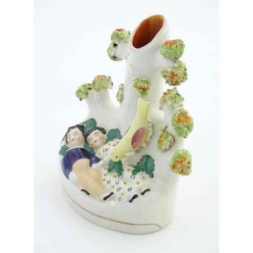 76 - A Staffordshire pottery bud vase with two sleeping children under a tree. Approx. 5 1/4