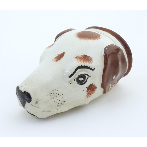 79 - A Victorian Staffordshire pottery stirrup cup formed as the head of a dog / hound. Approx. 4 1/2