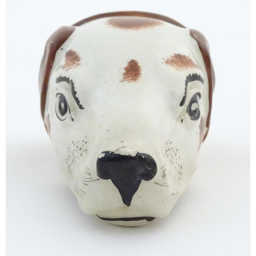 79 - A Victorian Staffordshire pottery stirrup cup formed as the head of a dog / hound. Approx. 4 1/2