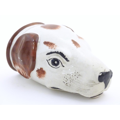 79 - A Victorian Staffordshire pottery stirrup cup formed as the head of a dog / hound. Approx. 4 1/2