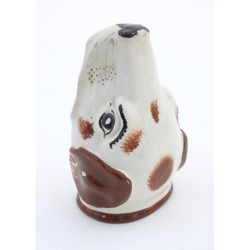 79 - A Victorian Staffordshire pottery stirrup cup formed as the head of a dog / hound. Approx. 4 1/2