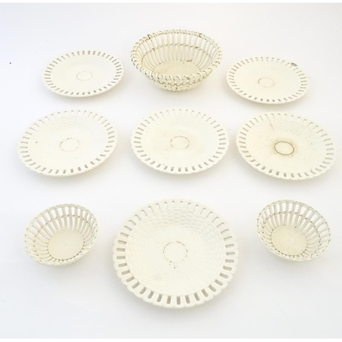 82 - A quantity of Continental creamware chestnut baskets, plates and dishes with reticulated detail. Wit... 